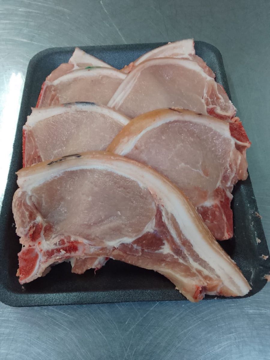 Thick-cut bone-in pork loin chops on a tray