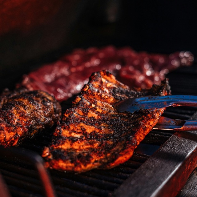 Basted ribs cooking low and slow on the grill